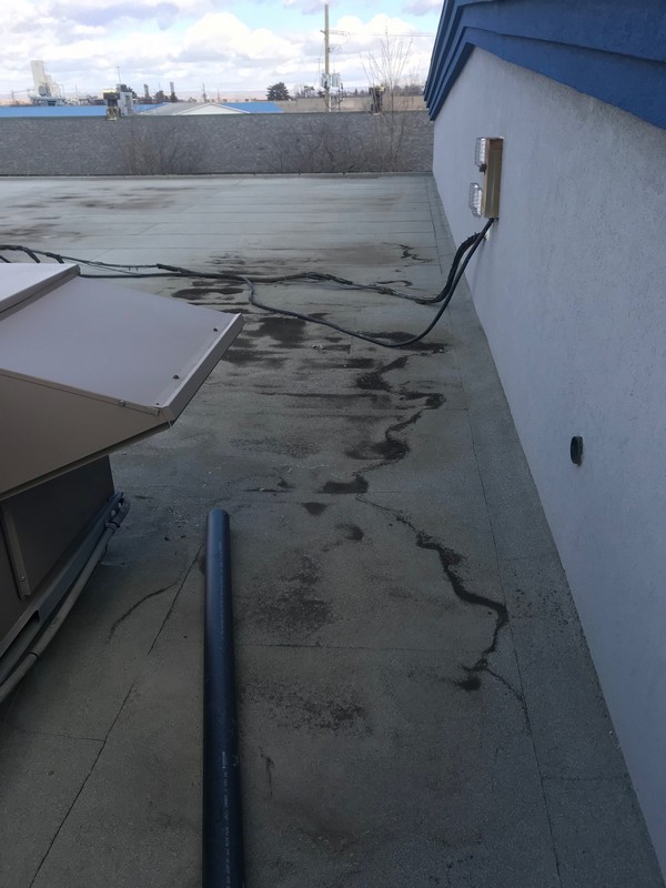 Flat roof membrane repairs at mechanical unit on industrial building in Ajax Roofing Repair