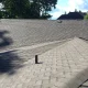 Asphalt shingle roof on a residential home with a plumbing vent and roof vent