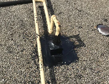 Rubberized sealant application for flat roof repair by Metro Roofing